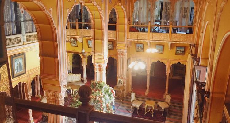 Interior of a palace with golden decor and arches.