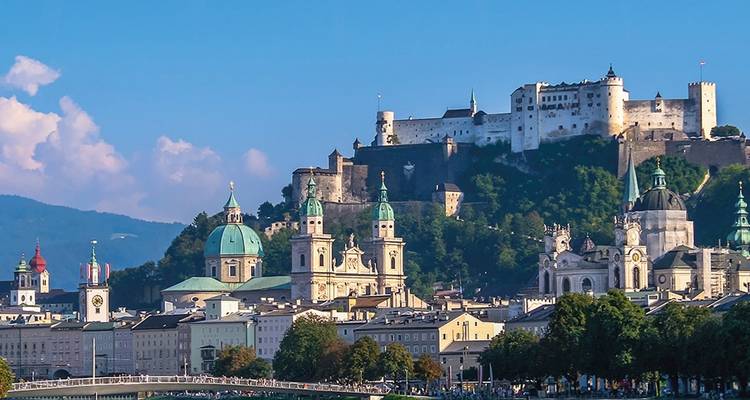 Panorama del horizonte barroco de Salzburgo coronado por la Fortaleza Hohensalzburg contra las montañas alpinas.