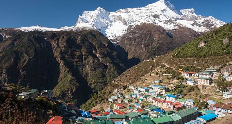 Bergdorp met kleurrijke gebouwen en een besneeuwde achtergrond.