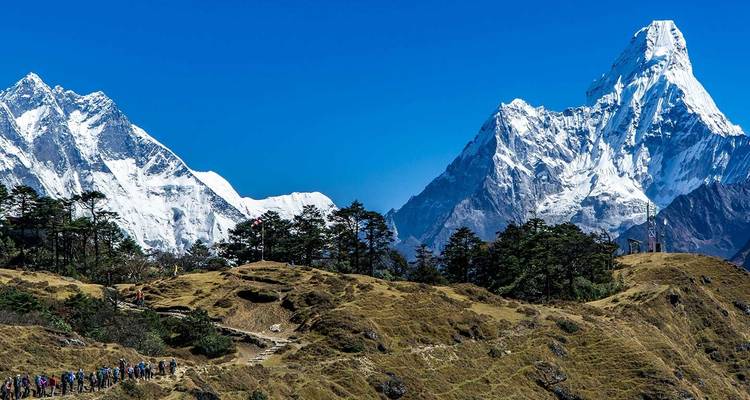 Groep trekkers met op de achtergrond hoge toppen.