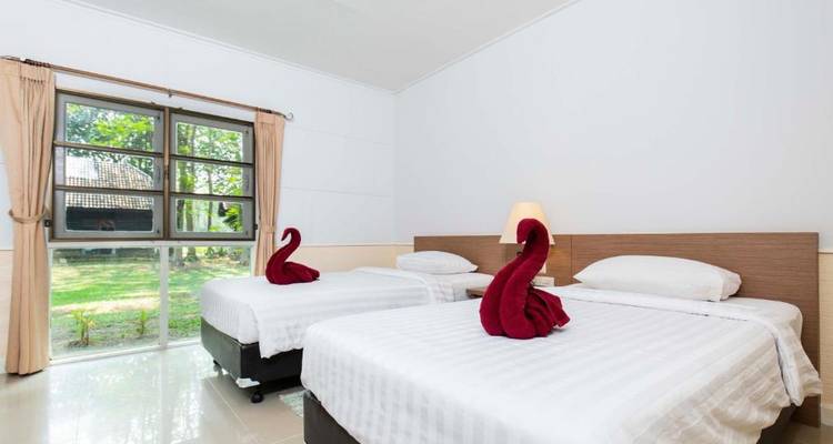 Ein Zimmer mit zwei Einzelbetten und Blick auf den Garten.