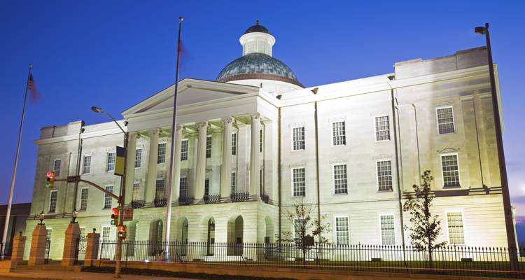 Historic white building illuminated at night.