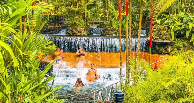 Des gens profitant de sources chaudes au milieu d'une végétation luxuriante