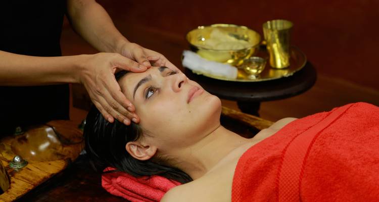 Person receiving a head massage in a spa setting.