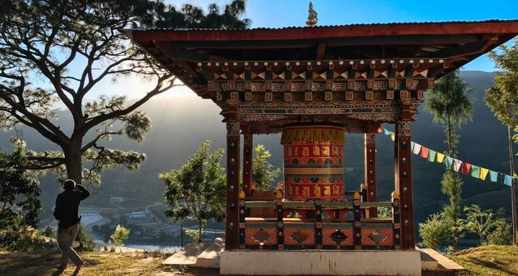 Person photographing a traditional prayer wheel in Bhutan.