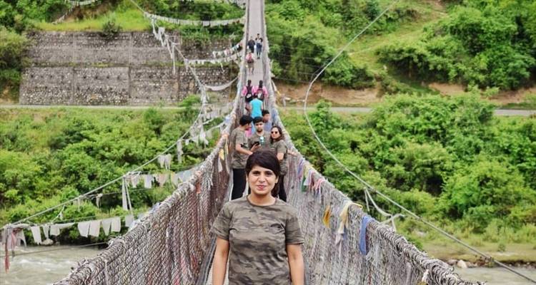 Tourist auf einer Hängebrücke mit Gebetsfahnen