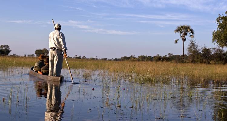 Personne pagayant dans un canoë traditionnel sur une voie navigable.