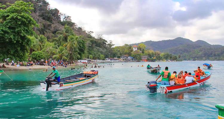 Barcos transportando personas en una pintoresca ribera tropical.