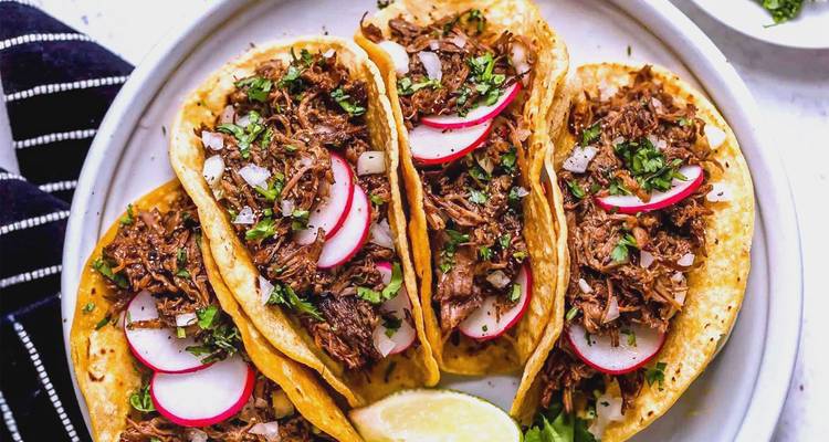 Plato de tacos con adorno de rábano y lima.