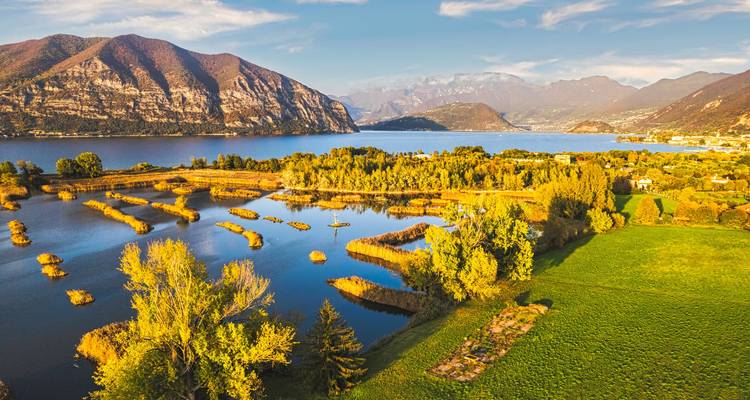 Vue aérienne d'un lac avec des îles et des montagnes environnantes.