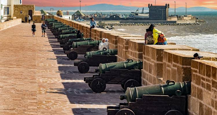 Forteresse au bord de mer avec des canons et des gens qui profitent de la vue