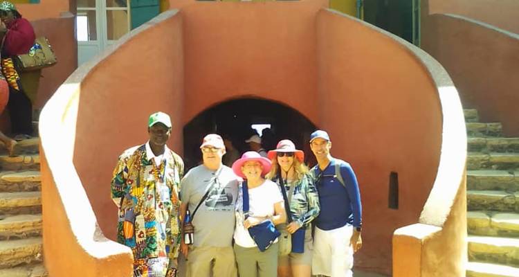 Gruppe von Menschen, die vor einem historischen Gebäude mit einem gewölbten Eingang stehen.