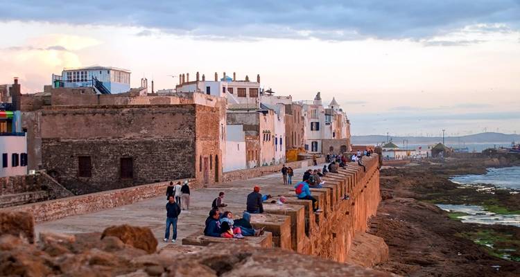 Menschen, die auf historischen Mauern in Essaouira, Marokko sitzen.