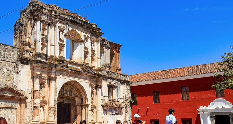 Ruines sous un ciel bleu dégagé avec des visiteurs qui explorent.