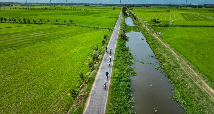 Luftaufnahme von Radfahrern auf einer langen Landstraße.