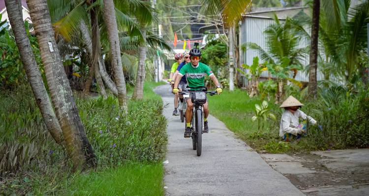 Radfahrer auf einem Weg durch ein tropisches Gebiet.