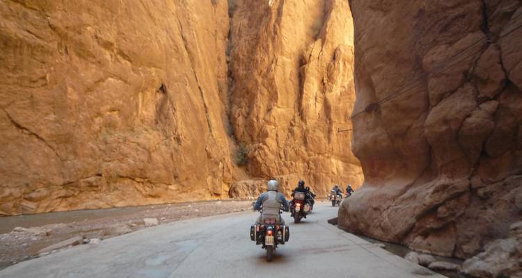 Motorradfahrer fahren durch eine felsige Schlucht.