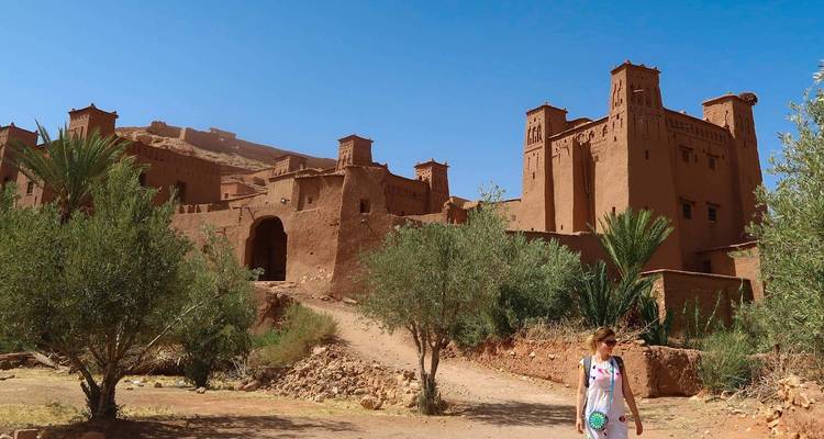Personne marchant près de bâtiments historiques en argile.