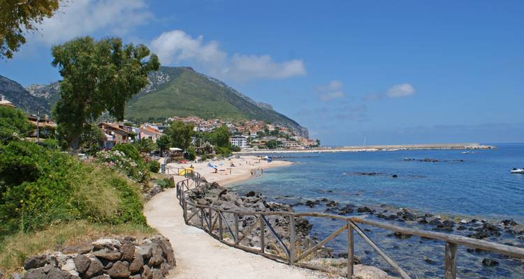 Ville côtière avec une plage et des montagnes.