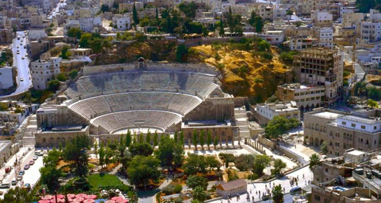Groot oud amfitheater in een stedelijke omgeving.