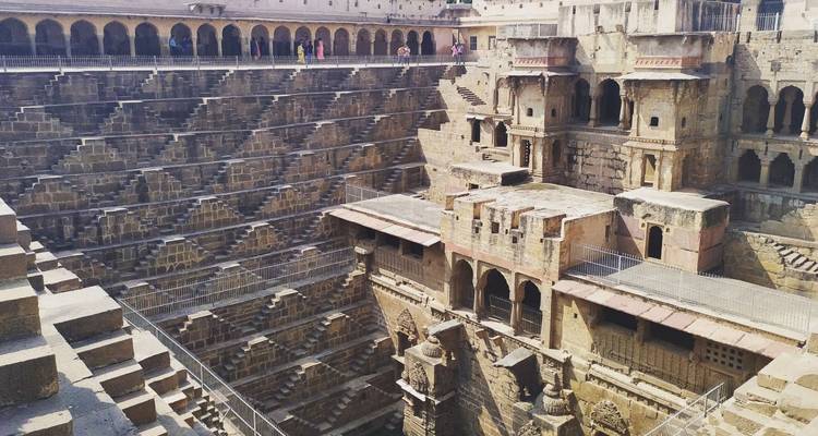 Un pozo escalonado de diseño intrincado con múltiples niveles y personas en la parte superior.