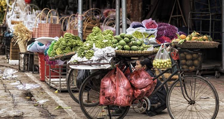 Ein Straßenhändler, der frisches Obst und Gemüse auf einem Fahrrad verkauft.