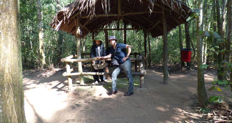 Zwei Menschen stehen in der Nähe einer Hütte in einem Waldgebiet.