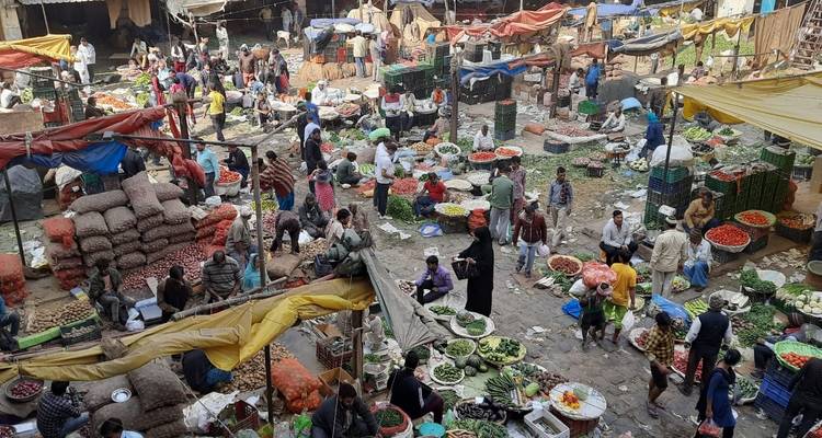 Bustling open-air market with vendors and shoppers.