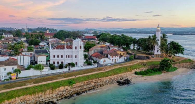 Historische kustplaats met een vuurtoren aan zee.