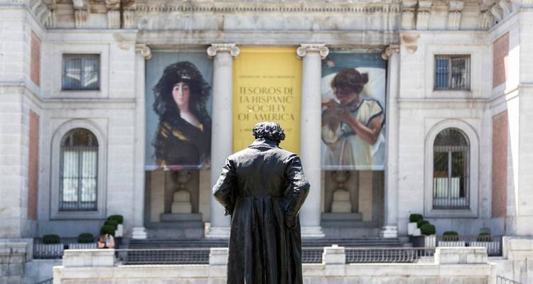 Statue devant un bâtiment avec des bannières artistiques.