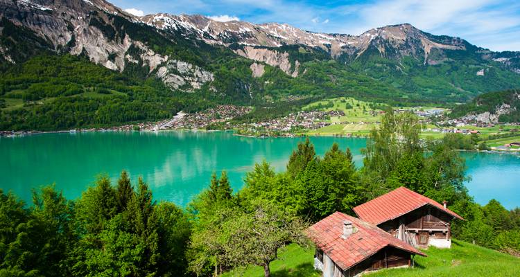 Malerische Aussicht auf einen See, umgeben von Häusern und Bergen.