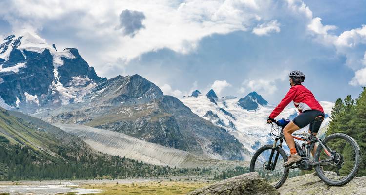 Radfahrer in einer Berglandschaft mit Gletschern.