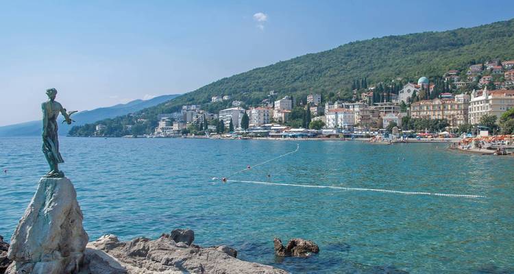 Statue mit Blick auf das Meer und einer Stadt im Hintergrund