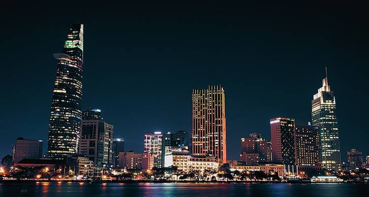 Skyline van de stad bij nacht met reflecties op het water.