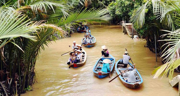 Toeristen in roeiboten die een junglerivier bevaren.