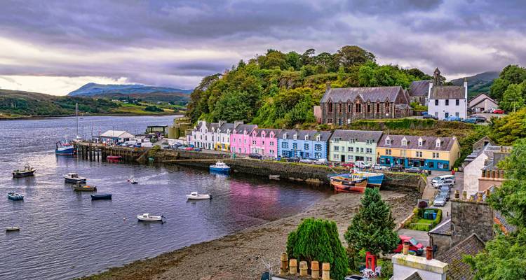 Des bâtiments colorés bordent un port avec des bateaux dans l'eau.