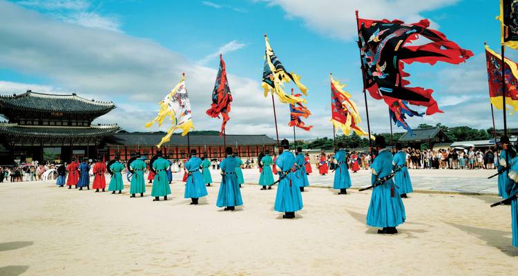 Ceremonia vibrante de la guardia real con banderas coloridas en el patio de un gran palacio Joseon.