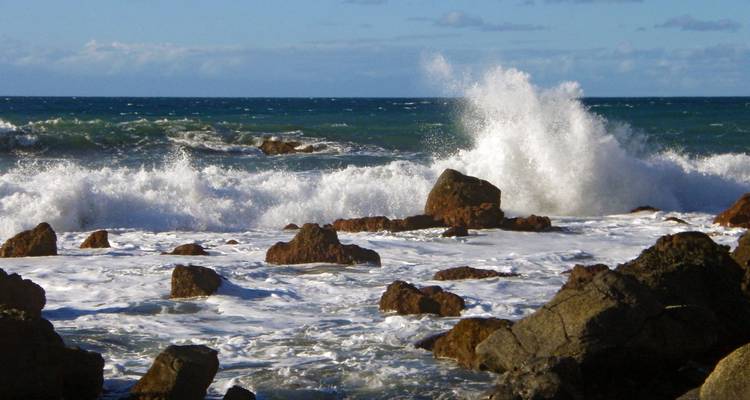 Olas estrellándose contra la costa rocosa.