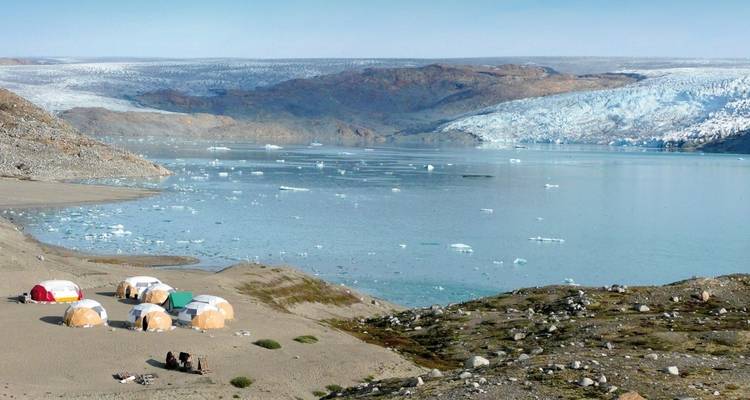Tents at a coastal campsite with views of an icy sea.