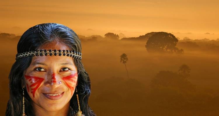 Une personne avec de la peinture faciale traditionnelle devant un paysage brumeux.