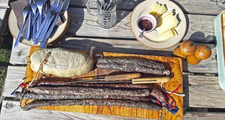 Saucissons traditionnels et fromage sur une table rustique en bois.