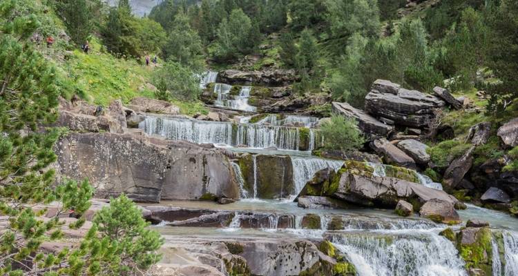 Natuurlijke waterval met rotsen en bomen eromheen.
