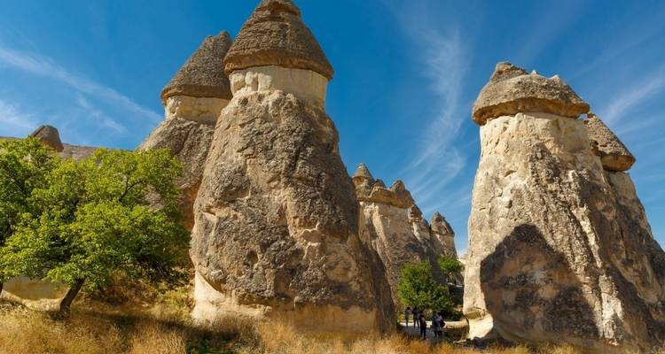 Unique rock formations in Cappadocia with people exploring.