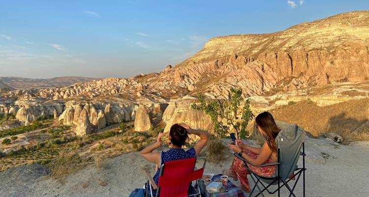 People relaxing with a view of rock formations.