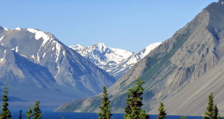 Valley view with a deep blue lake surrounded by steep mountains.