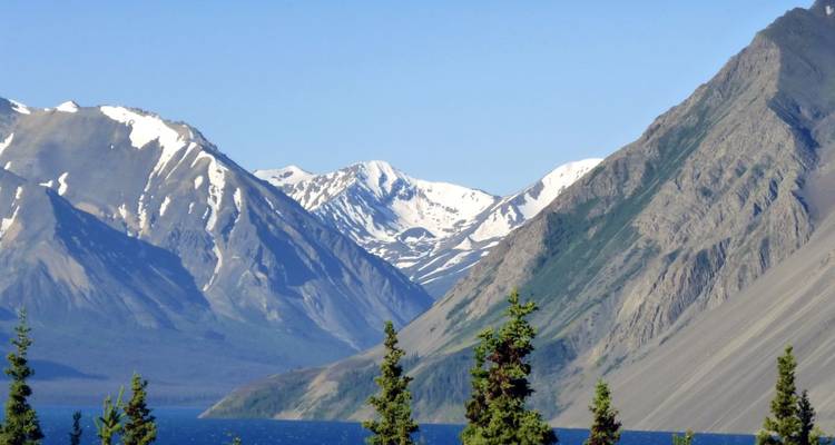 Mountain range with snow-capped peaks and a lake.