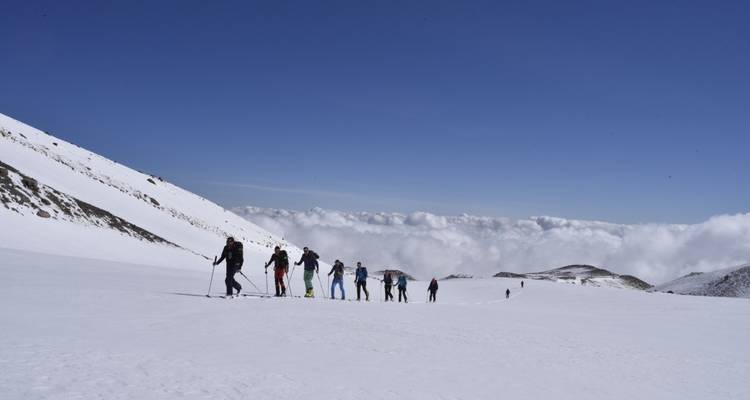 Senderismo grupal en una pendiente cubierta de nieve.