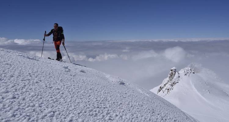 Persona haciendo esquí de travesía en una montaña nevada.