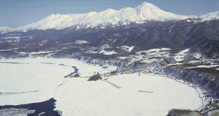 Vue aérienne d'un paysage enneigé avec des montagnes.