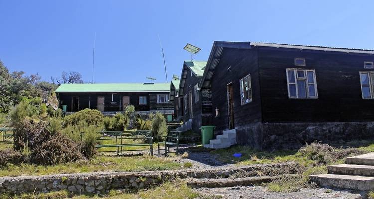 Gruppe von Hütten im Alpenstil in einer Berglandschaft.